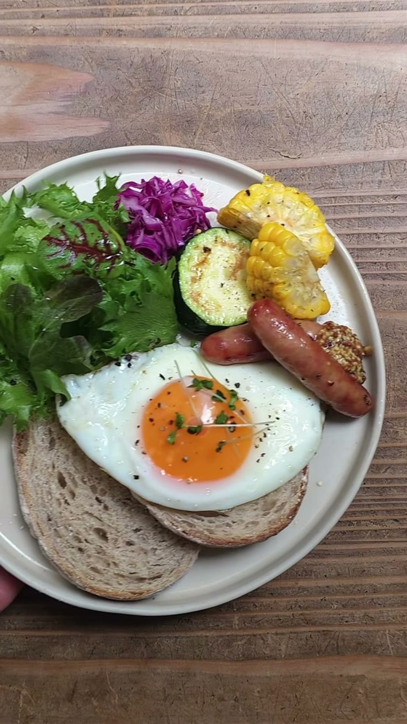 PAUSE COFFEEのパン、目玉焼き、ソーセージ、野菜を盛り付けたモーニングプレート